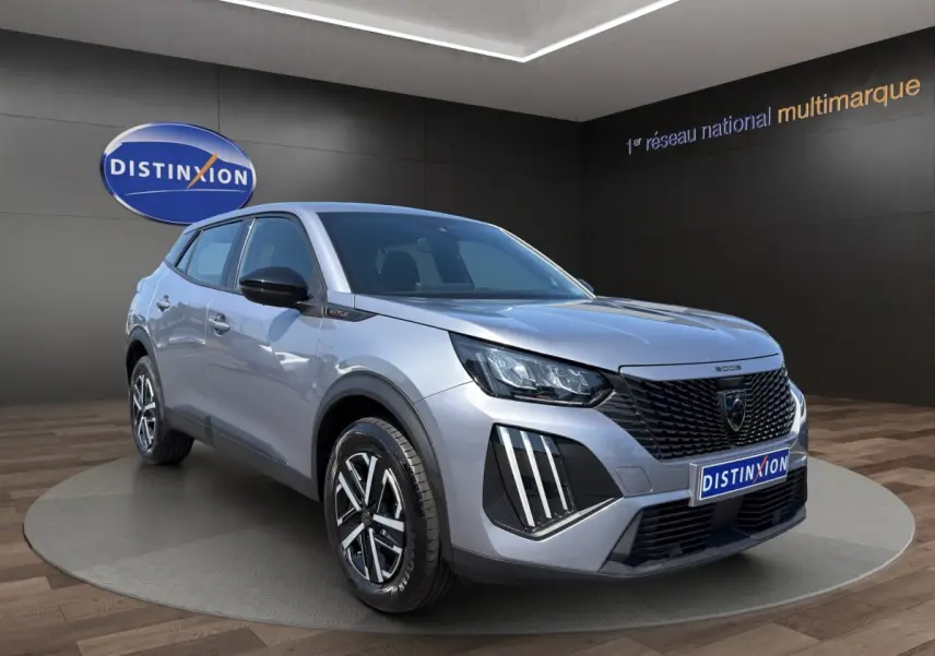 Peugeot 2008 Hybrid 145 e-DCS6 STYLE gris clair en 3/4 avant droit, avec calandre noire et feux LED distinctifs.