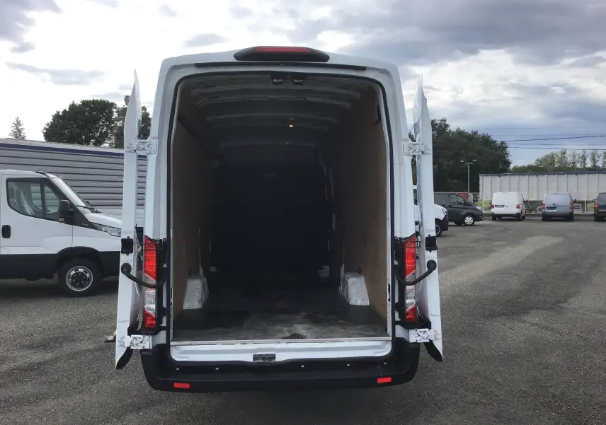 Vue arrière d'un Ford Transit Fourgon blanc 2020 avec portes ouvertes montrant l'espace de chargement vide.