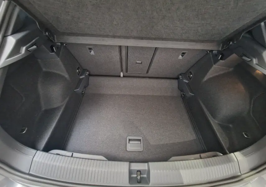 Coffre ouvert du Volkswagen T-Roc 2025 gris Indium Metal, montrant un espace de chargement propre et bien agencé.