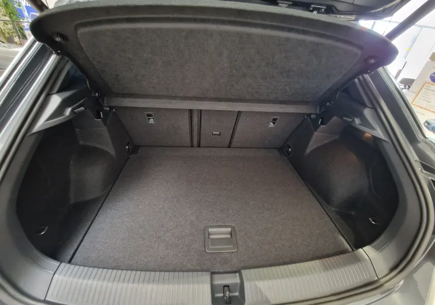 Coffre ouvert du Volkswagen T-Roc 2025 gris Indium Metal, montrant un espace de chargement propre et bien agencé.