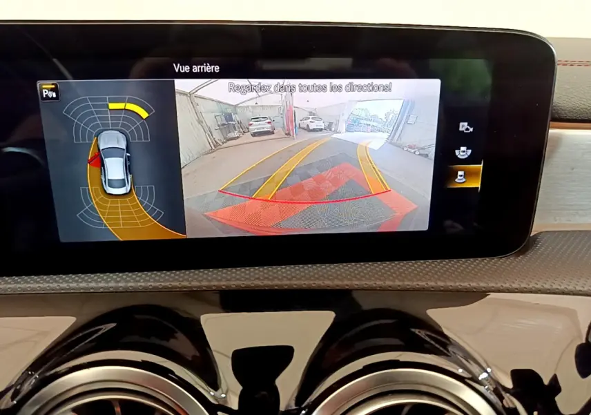 Écran tactile intérieur de la Mercedes CLA 200 d AMG Line noir montrant la caméra de recul avec aides au stationnement.