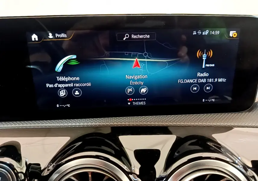 Écran tactile central affichant navigation et radio sur tableau de bord noir brillant d'une Mercedes CLA 200 d AMG Line.