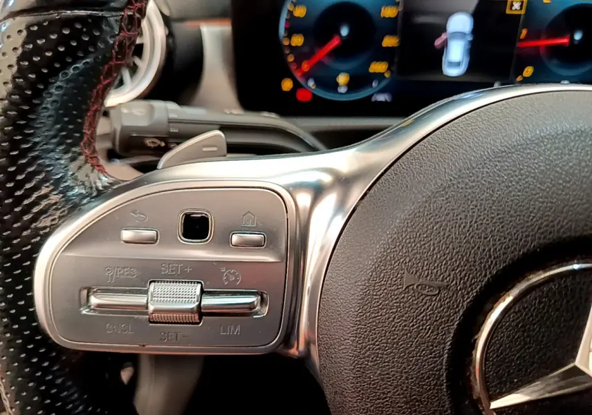 Gros plan sur le volant cuir noir de la Mercedes CLA 200 d AMG Line 2021 avec commandes multifonctions et tableau de bord numérique.