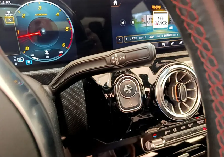 Détail intérieur du tableau de bord noir du Mercedes CLA 200 d AMG Line avec bouton start et levier de vitesses.