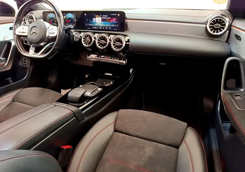 Intérieur noir du Mercedes CLA 200 d AMG Line 2021, vue de l'habitacle côté passager avec tableau de bord et volant multifonctions.
