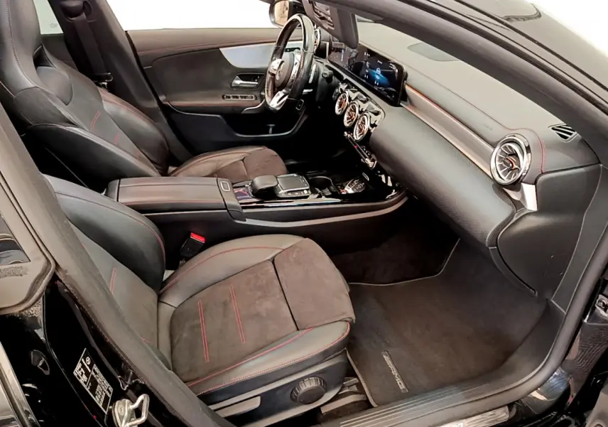 Vue intérieure côté passager de la Mercedes CLA 200 d AMG Line noire, sièges cuir et alcantara avec surpiqûres rouges.