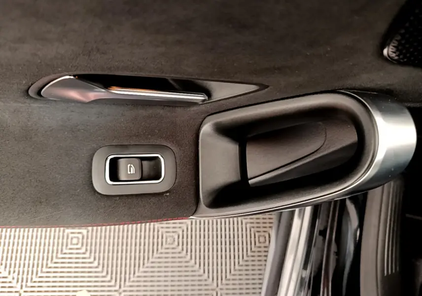 Poignée intérieure et commande de lève-vitre sur la porte côté gauche d'une Mercedes CLA 200 d AMG Line noire de 2021.