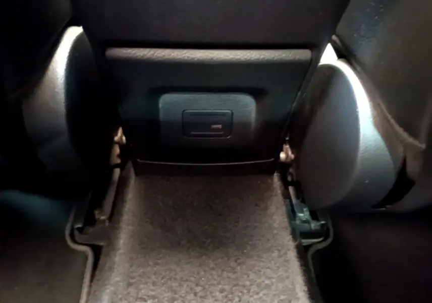 Prise USB située à l'arrière de la console centrale, entre les sièges arrière d'une Mercedes CLA 200 d AMG Line noire.