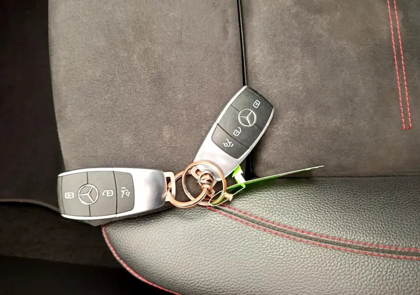 Clé Mercedes posée sur siège cuir noir et alcantara avec surpiqûres rouges, intérieur CLA 200 d AMG Line 2021.