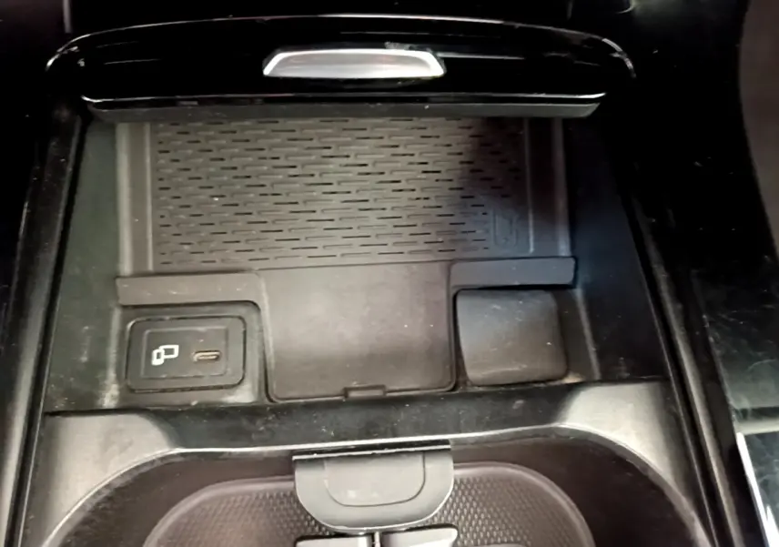 Vue rapprochée de la console centrale noire de la Mercedes CLA 200 d AMG Line avec chargeur sans fil et port USB-C.