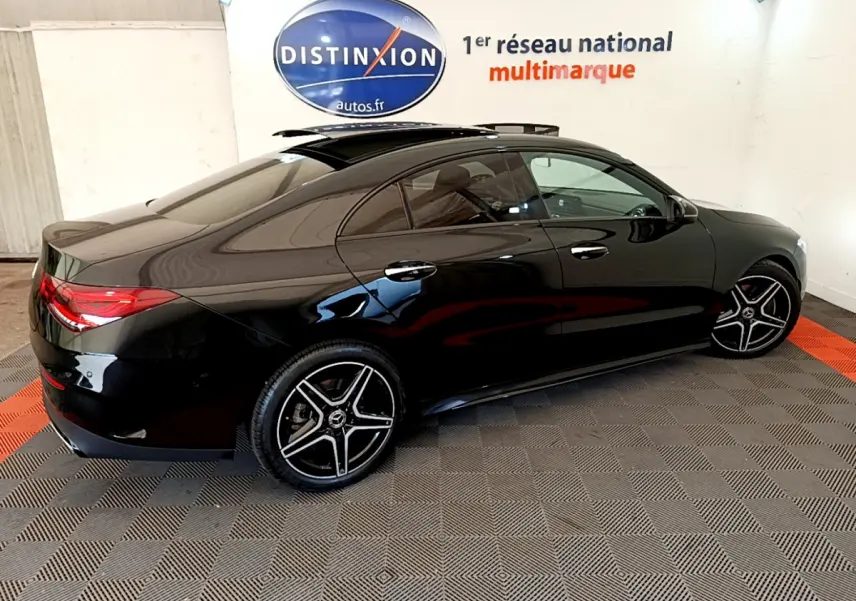 Vue 3/4 arrière côté gauche d'une Mercedes CLA 200 d AMG Line noire avec jantes AMG et toit ouvrant panoramique.