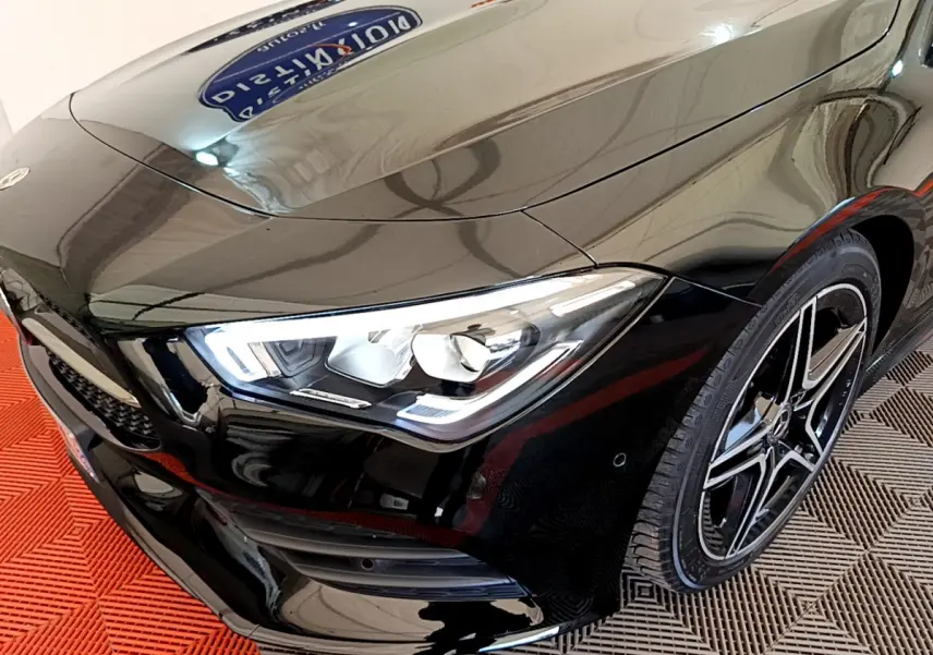 Vue 3/4 avant droit d'une Mercedes CLA 200 d AMG Line noire avec phares LED et jantes alliage distinctives.