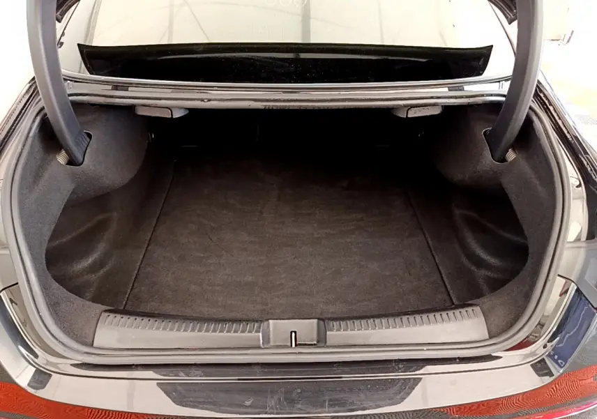 Coffre ouvert d'une Mercedes CLA 200 d AMG Line noir, vue arrière mettant en valeur l'espace de chargement.