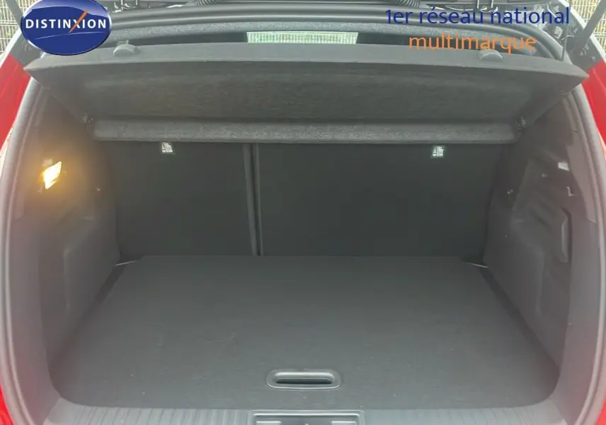 Coffre ouvert du Renault Captur E-Tech hybride rouge passion, vue arrière montrant l’espace de chargement vide.