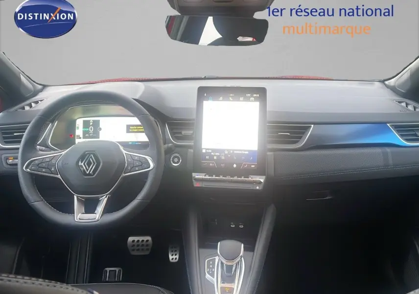 Vue frontale de l’habitacle du Renault Captur E-Tech rouge passion, avec tableau de bord numérique et écran tactile central.