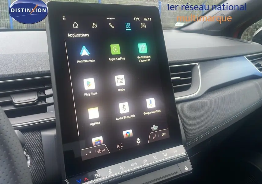 Écran tactile central vertical du tableau de bord du Renault Captur rouge passion, avec interface multimédia affichée.