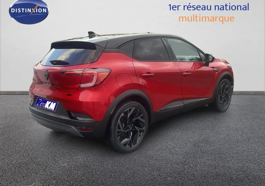 Vue 3/4 arrière droite d’un Renault Captur E-Tech hybride rouge passion avec toit noir et jantes noires.
