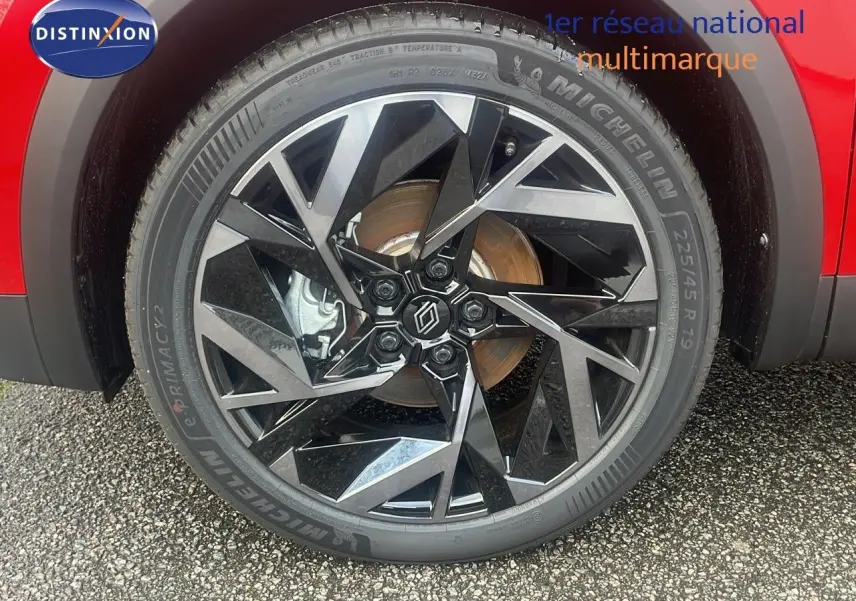 Gros plan sur la jante avant droite diamantée noire et argent du Renault Captur E-Tech rouge passion toit noir.