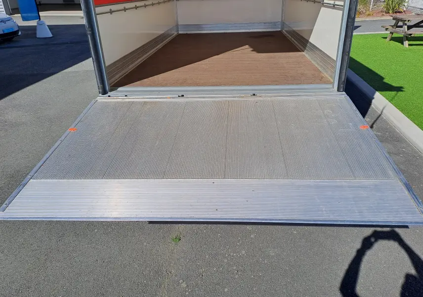 Vue arrière du Nissan Interstar châssis cabine blanc 2024, montrant la plateforme de chargement ouverte et l’intérieur vide.