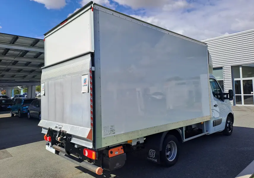 Vue 3/4 arrière droite d’un Nissan Interstar Chassis Cabine blanc 2024 avec caisse fermée et hayon élévateur.
