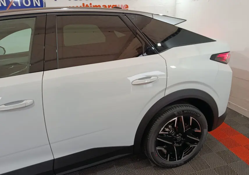 Vue latérale droite du Peugeot 3008 blanc hybride 2025, soulignant la roue arrière noire et les vitres teintées.