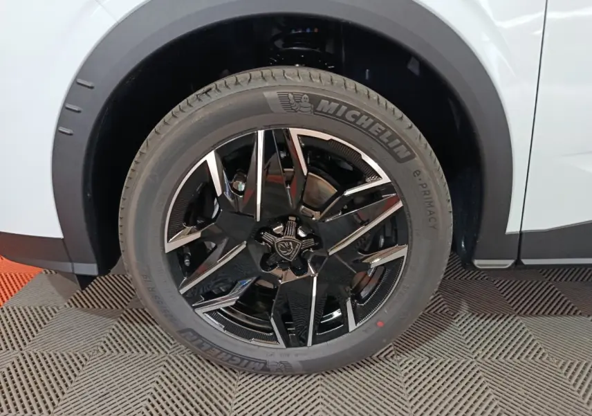 Gros plan sur la roue avant droite du Peugeot 3008 blanc 2025 avec jante noire et détails chromés.