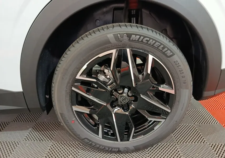 Gros plan sur la roue avant droite du Peugeot 3008 blanc, jante noire brillante au design moderne avec pneu Michelin.