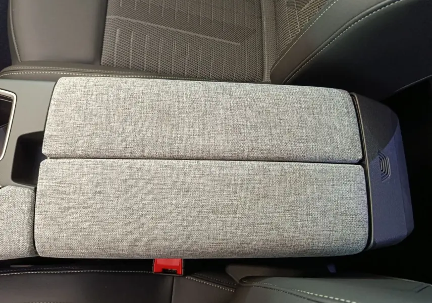 Accoudoir central en tissu gris clair vu de dessus dans l'habitacle du Peugeot 3008 1.2 HYBRID 145 GT blanc.