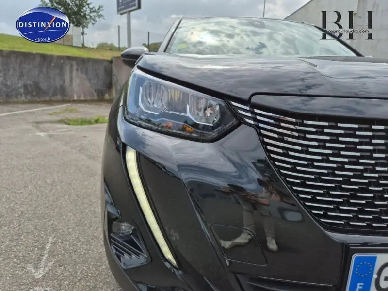 Gros plan sur l'avant droit du Peugeot 2008 noir Perla Nera avec phares LED et calandre distinctive.