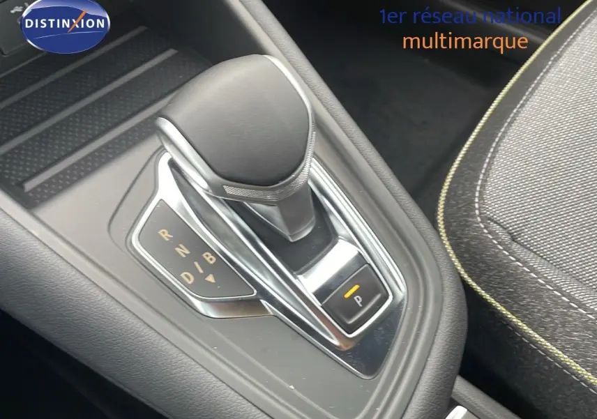 Le levier de vitesses automatique du Renault Captur E-Tech Hybrid 2025, avec sellerie tissu gris et surpiqûres jaunes.