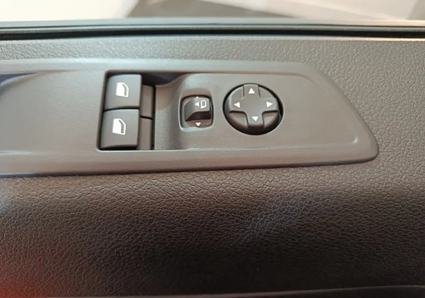 Gros plan sur les commandes de réglage des rétroviseurs et des vitres côté conducteur du Citroën Jumpy XL noir 2025.