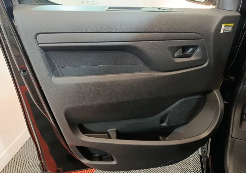 Porte intérieure côté gauche du Citroën Jumpy XL 2025 noir, avec poignée intégrée et haut-parleur visible.