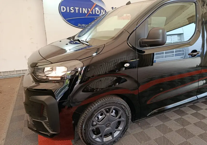 Vue 3/4 avant droit du Citroën Jumpy XL noir, mettant en valeur le phare allumé et la jante spécifique.