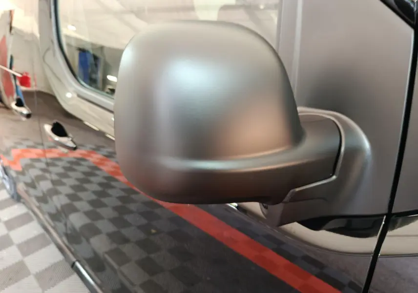 Rétroviseur côté conducteur noir mat du Citroën Jumpy XL 2025, avec portière noire brillante en arrière-plan.