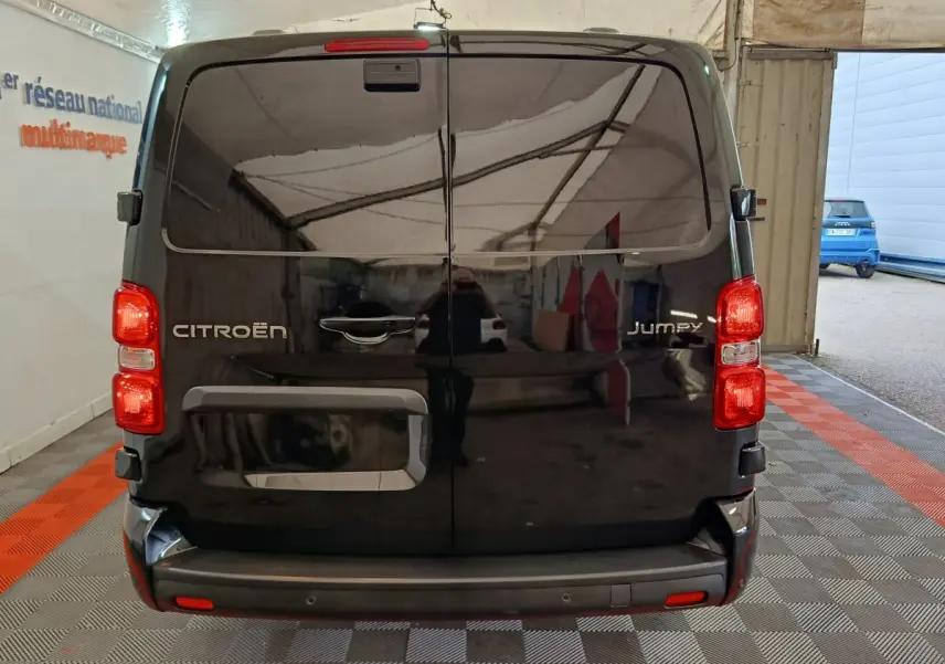 Vue arrière du Citroën Jumpy XL noir 2025 avec portes battantes et feux rouges visibles en intérieur showroom.