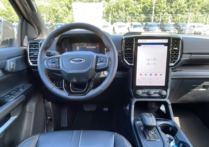 Vue intérieure avant du Ford Ranger 2026 gris carbone, volant cuir multifonctions et grand écran tactile vertical.