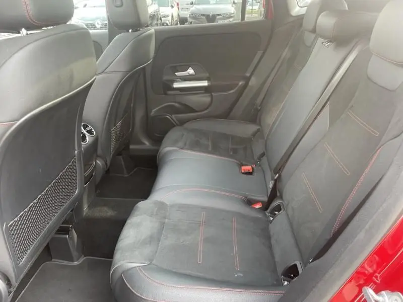 Vue intérieure arrière côté droit du Mercedes GLA 200 D AMG-LINE 2022 rouge métal, sièges en cuir noir avec surpiqûres rouges.