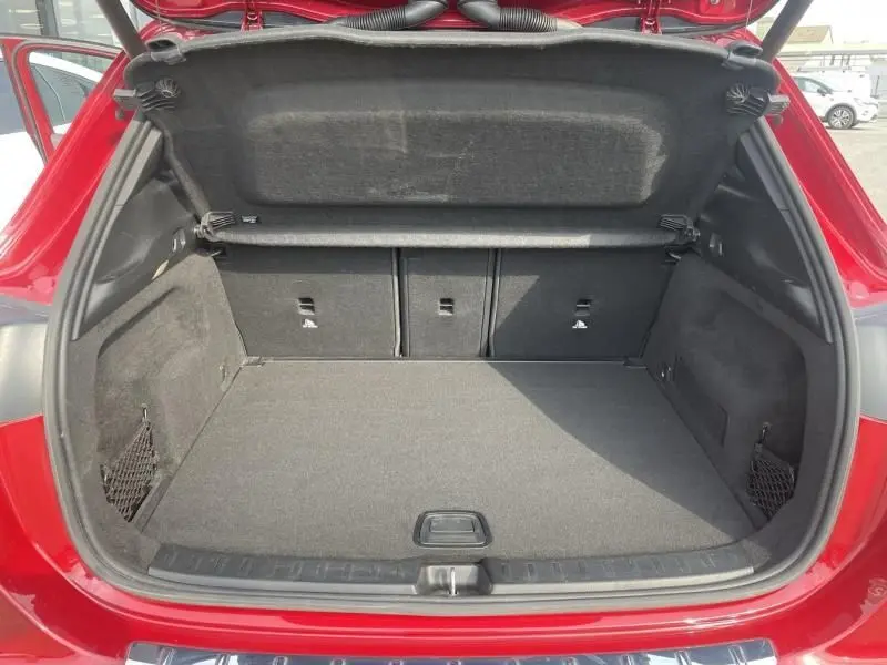 Coffre ouvert vu de l'arrière du Mercedes GLA 200 D AMG-LINE rouge métal, montrant un espace de chargement propre et spacieux.