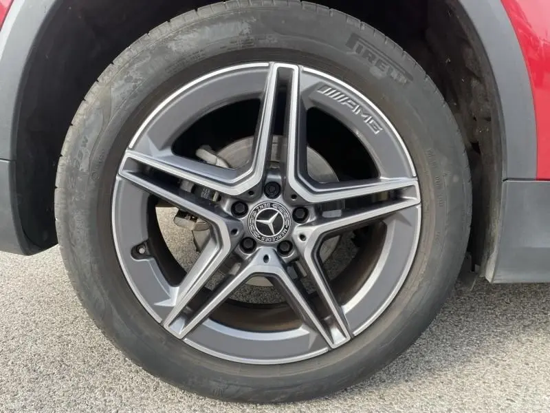 Gros plan sur la jante AMG en alliage gris du côté avant droit d’un Mercedes GLA 200 D rouge métal 2022.