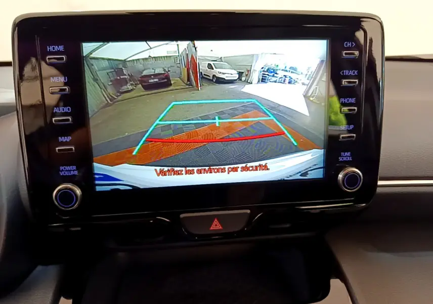 Écran tactile central affichant la caméra de recul du Toyota Yaris Cross blanc, avec guidage de stationnement coloré.
