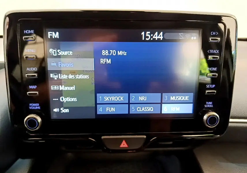 Écran tactile central affichant la radio FM avec stations présélectionnées dans une Toyota Yaris Cross blanche 2022.