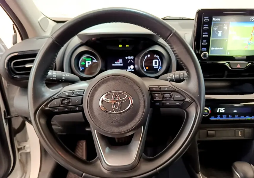 Vue centrée sur le volant cuir noir et tableau de bord numérique de la Toyota Yaris Cross blanche 2022 hybride