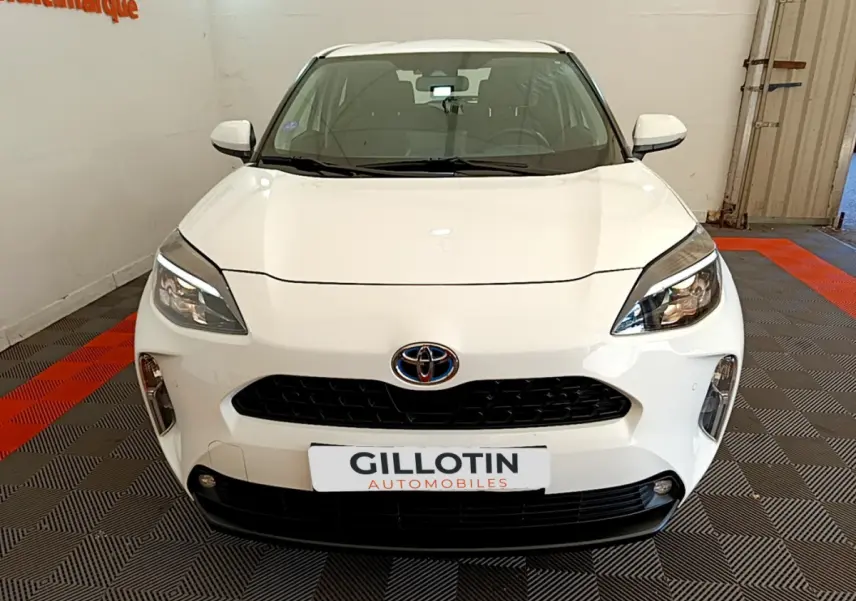 Vue frontale d'une Toyota Yaris Cross blanche 2022 avec calandre noire et phares LED distinctifs.
