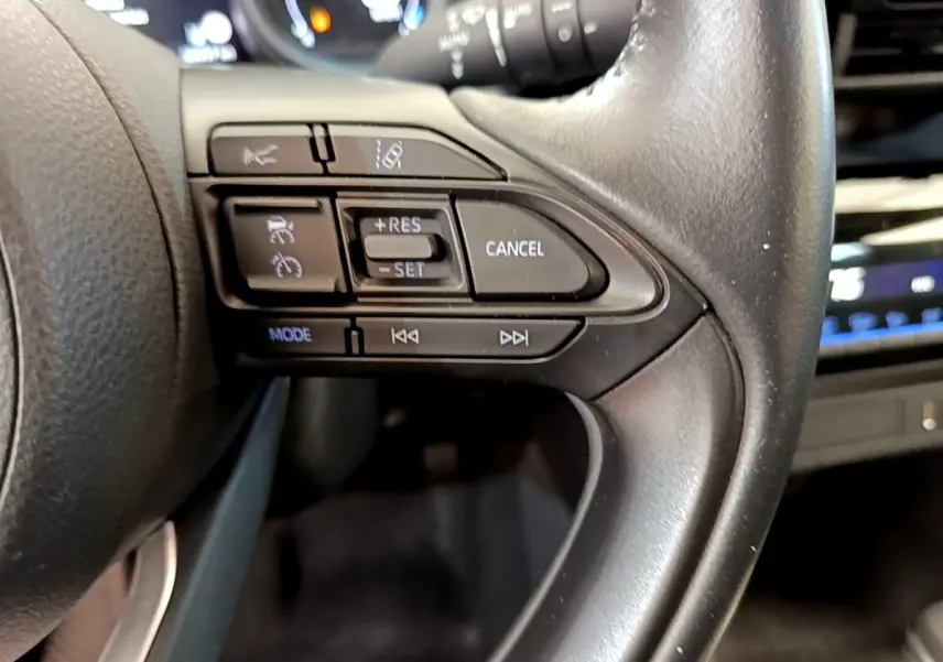 Gros plan sur les commandes du volant cuir côté droit du Toyota Yaris Cross blanc 2022, version hybride.