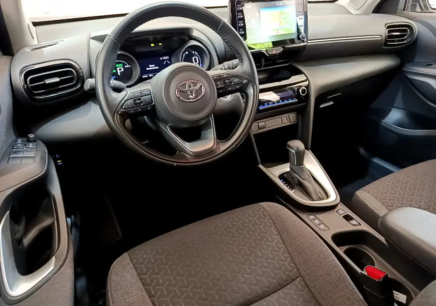 Intérieur noir et gris de la Toyota Yaris Cross 2022, vue côté conducteur sur volant cuir et écran tactile central.