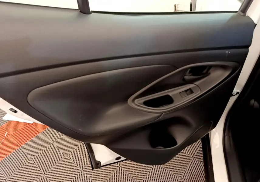 Gros plan sur la porte arrière droite noire intérieure du Toyota Yaris Cross blanc 2022, avec poignée et commande fenêtre.