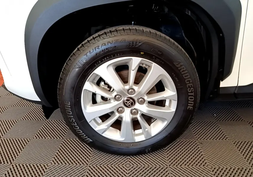Gros plan sur la roue avant gauche blanche du Toyota Yaris Cross 1.5 Hybrid avec jante alliage et pneu Bridgestone.