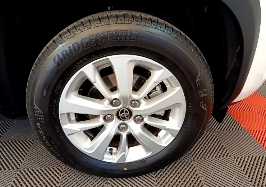 Gros plan sur la roue avant droite blanche d'une Toyota Yaris Cross 2022 avec jante alliage et pneu Bridgestone.