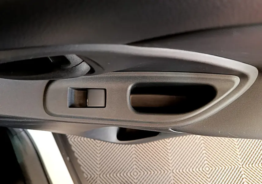 Poignée intérieure côté gauche noire de la porte d'une Toyota Yaris Cross blanche 2022, vue rapprochée.