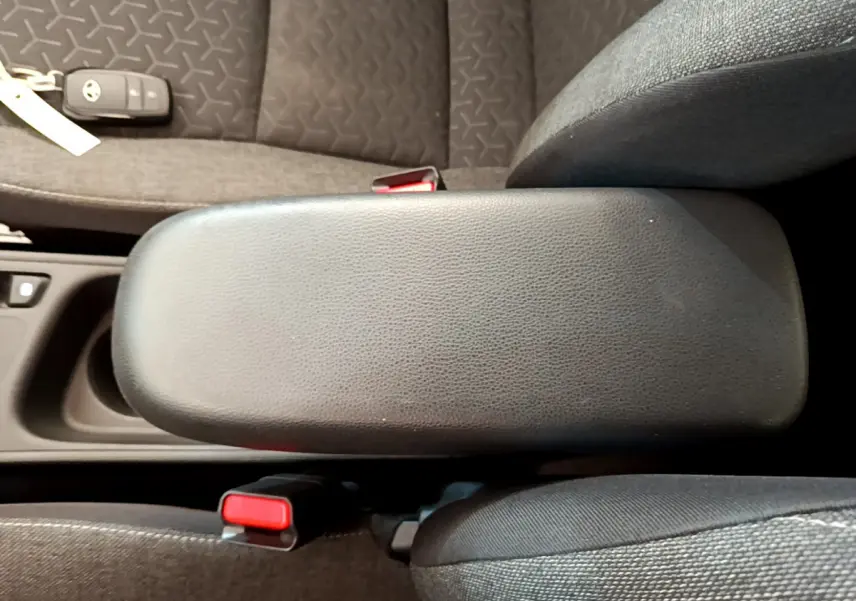 Vue rapprochée de l'accoudoir central noir et des sièges gris foncé de la Toyota Yaris Cross 2022 hybride.